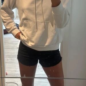 Svarta jeansshorts med rå kant - Snygga svarta jeansshorts med rå, fransig kant nertill. Modellen är tight och perfekta för varma sommardagar. Enkla att matcha med allt och ger en cool vibe till din outfit. Storlek 32 men passar 34 med. Skriv för fler bilder💗