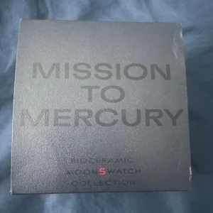 Omega x Swatch MoonSwatch Mercury - Säljer en Omega x Swatch MoonSwatch Mission to Mercury. Klockan har en mörkgrå boett i biokeramik, svart urtavla med vita detaljer och tachymeter, samt ett grått textilband med Swatch-logga. Ikonisk Speedmaster-design och cool space vibe. Använd lite pris kan diskuteras