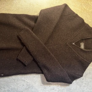 Brun stickad tröja Björn Borg - Mysig brun stickad tröja från Björn Borg i storlek M. Tröjan har en ribbad krage med half zip-dragkedja och långa ärmar. Perfekt för kyliga dagar när du vill ha en stilren och enkel look.