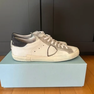 Philippe Model vita sneakers i skinn - Tjena! Säljer ett par vita skor från Philipe model i storlek 41, skorna köptes i juni månad. Så rätt så nya, startpris börjar på 1999. Priset kan såklart sänkas lite! OBS det är lite blåfärg kvar men går såklart att få bort!