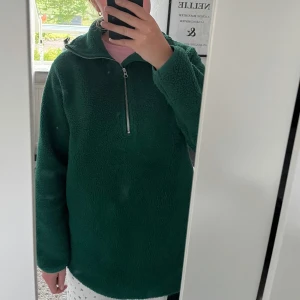 Mörkgrön fleece-tröja med half zip - Mysig mörkgrön fleece-tröja med halv dragkedja framtill och hög krage. Tröjan har en loose passform och långa ärmar, perfekt för kyliga dagar☘️🌸