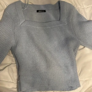 Ljusblå stickad tröja Gina Tricot - Superfin ljusblå stickad tröja från Gina Tricot med fyrkantig ringning och breda ribbade muddar. Tröjan har lång ärm och är perfekt för lager-på-lager. Snygg till både jeans och kjol, och ger en chill men ändå stilren vibe.