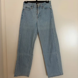 Ljusblå raka jeans från Lee - Säljer ett par klassiska ljusblå jeans från Lee med raka ben och normal passform. Jeansen har fem fickor, bälteshällor och Lee-logga på knappen och bakfickan. Perfekt vintagekänsla och tillverkade i robust denim.
