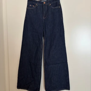 Mörkblå wide jeans från Zara - Snygga mörkblå jeans från Zara med hög midja och breda ben. Klassisk femficksmodell med kontrastsömmar och ZARA-logga bak i midjan. Perfekta för dig som gillar en trendig och avslappnad look. Aldrig använda!