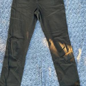 Olivgröna straight jeans Denim Style - Snygga olivgröna jeans från Denim Style med klassisk femficksdesign och raka ben. Byxorna har normal passform och är tillverkade i bomullstyg med en skön känsla. Perfekta för dig som gillar en enkel och clean look.