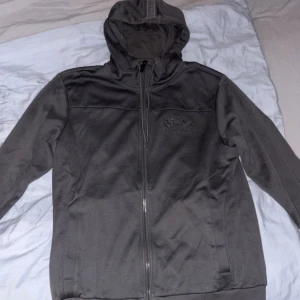 Grå hoodiejacka från Hugo Boss - Grå Hugo boss tröja, gammal model storlek S. Är presic som nyskick och absolut inga problem med den, de är inget alls som är isönder heller. Pris går att diskuteras