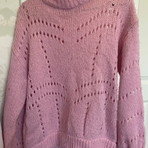 Rosa stickad tröja Gina Tricot - Supermysig rosa stickad tröja från Gina Tricot med snygga hålmönster och ribbade muddar. Perfekt för lager-på-lager och ger en chill vibe till din outfit. Långärmad och lite oversized känsla.