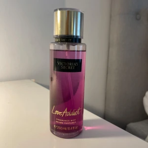 Victoria's Secret Love Addict mist - Love Addict från Victoria's Secret är en body mist i en snygg genomskinlig plastflaska med lila-rosa vätska och guldig kork. Rymmer 250 ml och har en fräsch, söt och ungdomlig doft. Perfekt för dig som gillar fruktiga och blommiga toner.