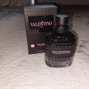 Valentino Uomo Born In Roma Intense 100ml - Valentino Uomo Born In Roma Intense Eau de Parfum 100ml. Flaskan är i svart och transparent glas med nitar och en lyxig känsla. Märkets logga i rosa på svart etikett. Snygg och modern design som sticker ut i badrumshyllan.