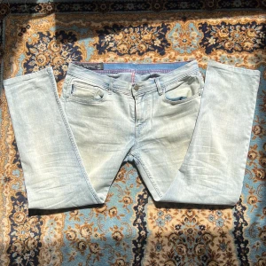 Ljusblå Armani Exchange jeans  - Snygga ljusblå jeans från Armani Exchange i slim fit-modell. Tillverkade i bomull med lite stretch för extra komfort. Perfekta för en avslappnad och trendig look. Har någon enstaka fläck men är i övrigt sparsamt använda.