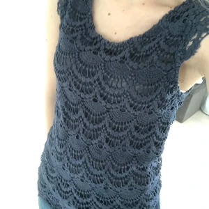 Mörkblå spetsblus från Object - Supersnygg mörkblå blus från Object med vackert virkad spets och fodrad insida. Ärmlös modell med rund halsringning och dragkedja bak. Perfekt för dig som vill ha en unik och stilren topp med coola detaljer.