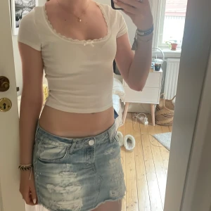 Vit croppad topp med spets från H&M - Supersöt vit topp med spets från H&M Divided i ribbad bomull. Endast använd fåtal gånger och är i fint skick, hör av er vid funderingar 💕