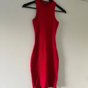 Röd ribbad klänning från FB Sister - Snygg röd ribbad kortklänning från FB Sister. Ärmlös modell med tight passform och rund halsringning. Perfekt för dig som gillar en enkel men ändå iögonfallande stil. Materialet är stretchigt och följsamt för en bekväm känsla.