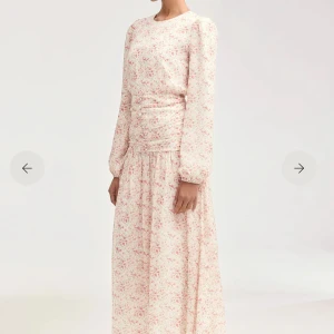 Ljusblommig långklänning med puffärm - Romantisk långklänning i ljus ton med småblommigt mönster i rosa och grönt. Klänningen har långa puffärmar, rund halsringning och rynkade detaljer i midjan. Perfekt för sommarens alla tillfällen när du vill känna dig extra fin.