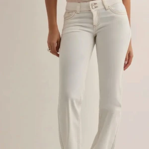 Vita Lågmidjade bootcut jeans  - As snygga vita Lågmidjade jeans i storlek 32. Jeansen är aldrig använde och har prislapp kvar. Råkade köpa två i samma storlek därav måste jag sälja ett par. Jeansen är slutsålda i nästan alla storlekar. 🥰🤩