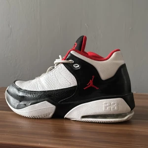 Jordan sneakers svart/vit/röd strl 42 - Snygga Jordan sneakers i svart, vitt och rött med klassisk Jumpman-logga på sidan och 23 på plösen. Skorna har lågt skaft, snörning och en robust sula med AIR-dämpning. Ovandelen är i skinn och textil, med röd mesh på insidan för extra komfort.