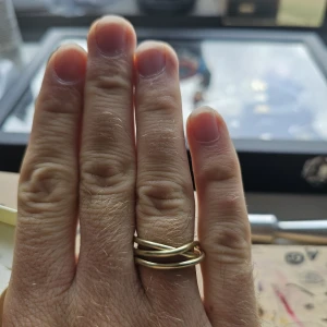 Handgjord Guldig wire-ring  - Handgjord ring i guldton med flera tunna slingor som korsar varandra och ger en unik, modern look. Den har en minimalistisk design och passar perfekt om du gillar statement-smycken med lite edge. Är i aluminium och är st 17.7 mm