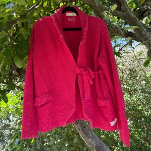 Rosa stickad kofta Odd Molly - Säljer en snygg rosa stickad kofta från Odd Molly med knytband i midjan och två fickor framtill. Koftan har långärmade ärmar och ett grovt stickat mönster som ger en cool struktur. Perfekt för dig som gillar färg och vill ha något unikt i garderoben! Storlek 3 som enligt deras storleksguide motsvarar en storlek L. Fint skick, men den är lite blekare än vad bilderna visar. Kan vara något blekt på olika ställen. 