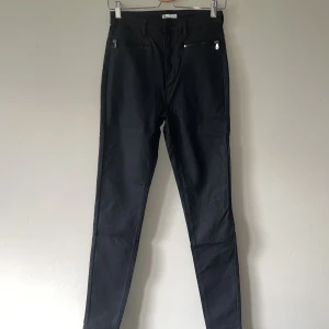 Coated zip pants / Nelly - Coated zip pants från Nelly. Aldrig använd, storlek 38. Gjord i läderimitation
