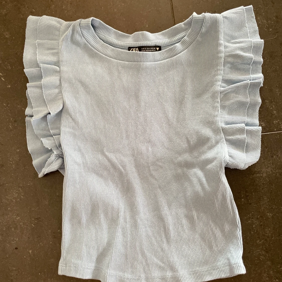 Ljusblå ribbad topp med volangärmar Zara