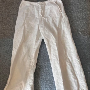 Vita linnebyxor från Kappahl med snörning - Snygga vita linnebyxor från Kappahl i storlek 146. Byxorna har elastisk midja med snörning och raka ben. Perfekta för varma dagar och ger en chill och fräsch look. Lätta att matcha med både t-shirt och skjorta.