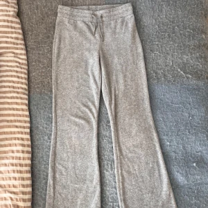 Grå mjukisbyxor från Gina Tricot - Gråa mjukisbyxor från Gina Tricot med bootcut-ben och snörning i midjan. Byxorna har två bakfickor och är gjorda i mjukt bomullsmaterial. Perfekta för chill dagar eller när du vill vara extra bekväm. Jag tror att det är storlek 146-152