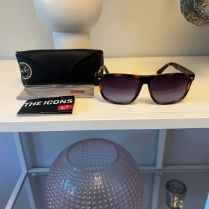 Ray-Ban Boyfriend  - Snygga Ray-Ban Wayfarer RB4147 med brunmelerad båge och mörka tonade glas. De är ej originalglas då de gått sönder! Klassisk fyrkantig form och ikonisk logga på skalmen. Kommer med originalfodral, putsduk och booklet. Perfekta för att lyfta din stil i solen. Hör av dig vid minsta lilla fundering!🤩😎