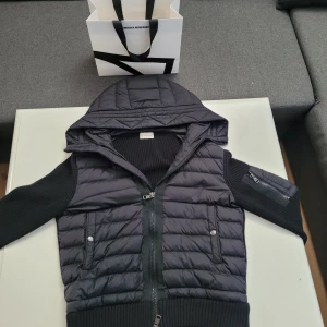 Svart jacka från Moncler - Snygg svart jacka från Moncler med quiltad design och huva. Jackan har dragkedja framtill och ribbade ärmar. Perfekt för kyligare dagar.