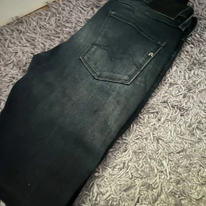 Replay mörkblå jeans  - Snygga mörkblå jeans från Replay med klassisk femficksdesign och raka ben. Jeansen har en normal passform och är tillverkade i slitstarkt denimtyg. Perfekt för dig som gillar stilrena och tidlösa jeans med cool tvätt och diskreta detaljer.
