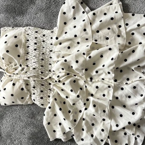 Vit prickig kortklänning med volanger - Supersöt vit kortklänning med svarta prickar, köpt i Spanien