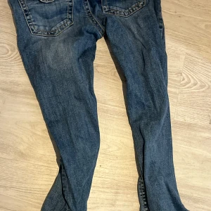 Blå Gina Tricot Perfect Jeans - Säljer ett par blå flared jeans från Gina Tricot, modellen Perfect Jeans. De har klassisk femficksdesign och raka ben med normal passform. Jeansen är tillverkade i jeansmaterial och har en snygg blå tvätt som passar till allt. Perfekt för dig som gillar stilrena och bekväma jeans.
