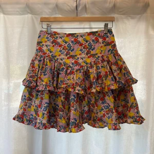 Blommig volangkjol från Custommade - Superfin kort kjol från Custommade med färgglatt blommönster i rosa, blått, gult, rött och grönt. Kjolen har volanger och en flowy passform som ger en lekfull vibe. Perfekt för dig som vill sticka ut med en färgklick i garderoben ❤️‍🔥