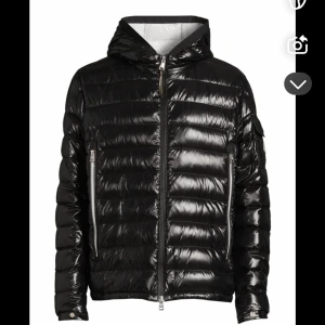 Svart glansig dunjacka med huva - Intressekoll på min svarta monclerjacka, finns ett litet hål på armbågen som ej syns, kvitto finns, nypris 9999