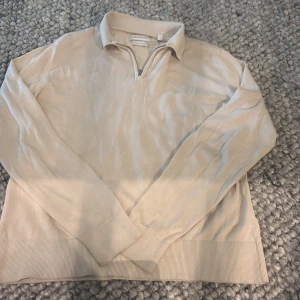 Beige half zip-tröja These Glory Days - Beige långärmad tröja från These Glory Days i mjuk bomull. Klassisk krage och half zip-dragkedja framtill ger en clean och stilren look. Ribbad mudd vid ärmslut och nederkant. Perfekt för dig som gillar minimalistisk stil. Nypris 1000kr. Liten skiftningar i färg vid armslut som det blir vid användning. 