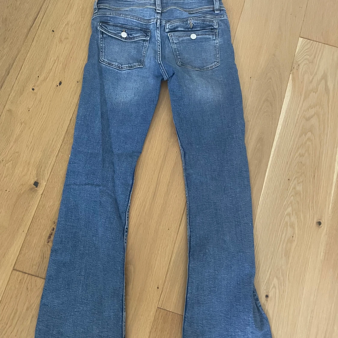 Blå bootcut jeans med slitningar