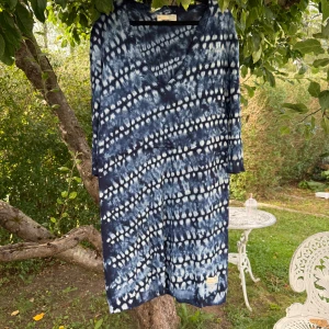 Blåvit mönstrad klänning Odd Molly - Snygg klänning från Odd Molly med blåvitt batikmönster och v-ringning. Klänningen har trekvartsärm och är tillverkad i mjuk bomull. Perfekt för dig som gillar unika mönster och avslappnad stil. Storlek 2 som enligt deras storleksguide motsvarar en storlek M.  Mycket fint skick, jag hittar inga synliga anmärkningar eller defekter.