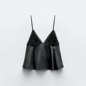 Zara topp - Supersnygg svart linnetopp i satin med tunna axelband och v-ringning. Överdelen har fina spetsdetaljer och blommiga broderier. Banden går att justera längd på. Inga defekter på. 