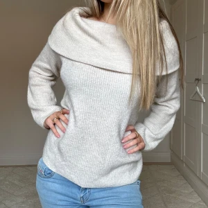 Beige stickad offshoulder tröja från H&M - Säljer en sååå mysig beige stickad tröja från H&M. Tröjan har en bred off-shoulder krage och långa armar. Tröjan är också ganska lång vilket gör den jättemysig att ha på sommaren tsm med en kjol! 