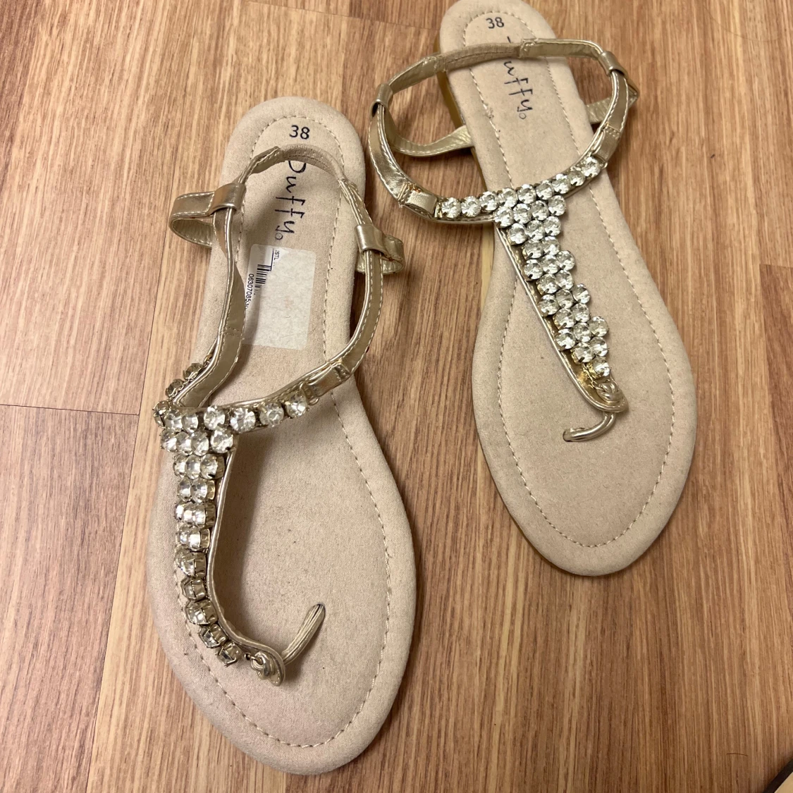 Guldiga sandaler med strassdetaljer