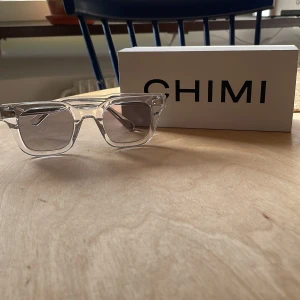 Solglasögon från CHIMI 04 Clear - Snygga glasögon från CHIMI i 04 Clear. De har en rektangulär form och kommer med ett matchande fodral. Perfekta för en modern look.😊