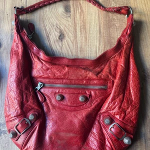 Sällsynt Balenciaga Day - Sällsynt Balenciaga Day väska i röd. Bra skick (skavanker syns på bilder). Inköpt på Vestiaire 2022 (Äkthetsintyg kan fås i DM). Kan hämtas på Östermalm, Stockholm eller skickas med spårbar frakt. 