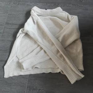 Vit stickad tröja för barn i 8-10 åldern - Säljer en mysig vit stickad tröja för barn i storlek 134/140, passande för åldern 8-10 år. Tröjan har långa ärmar och ribbstickade muddar vid ärmslut och nederkant. Perfekt för lite kyligare dagar!