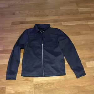 Mörkblå  över shirt med dragkedja - Snygg mörkblå övershirt med dragkedja framtill. Jackan har en klassisk krage och långa ärmar. Perfekt för en stilren look. Från Jack n Jones 
