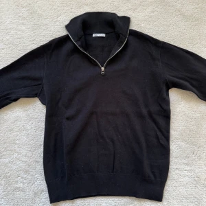 Svart tröja med dragkedja från Zara - Säljer en stilren svart tröja från Zara med dragkedja vid halsen. Perfekt för en avslappnad men ändå snygg look. Tröjan har långa ärmar och är tillverkad i ett mjukt material. Storlek S