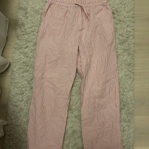 Randiga byxor med snörning - Säljer ett par bekväma byxor med rödvita ränder och snörning i midjan. 