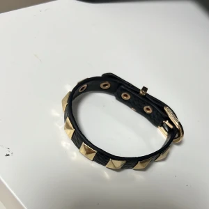 Armband - Svart armband med gulda nitar, aldrig använd 