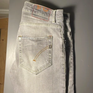 Ljusgrå jeansbyxor Dondup  - Snygga ljusgrå jeansbyxor från Dondup med klassisk femficksdesign och kontrastsömmar. Perfekta för en avslappnad stil. De har en midwaist passform och är tillverkade i slitstarkt denim.