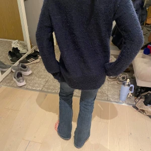 Mörkblå stickad tröja - Säljer en mysig mörkblå stickad tröja med långa ärmar. Perfekt för kyliga dagar med sin mjuka och varma känsla. Tröjan har ribbade muddar vid ärmslut och nederkant. ORGENSL PRIS: 599