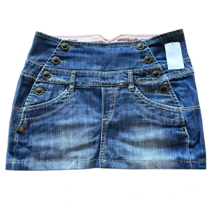 Blå jeanskjol med knappar - Sommrig blå jeanskjol med knappar! Knapparna går att öppna så den går att ändra til utseende en bit!💕                                                                           Midja mätt platt: 40cm                                                Längd på hela kjolen: 32cm