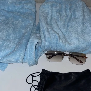 Solglasögon och Man Tracksuit - Snygga solglasögon med mörka linser och silverfärgade detaljer. Perfekta för en stilren look. Kommer med en praktisk svart förvaringspåse. Med Helt Ny tracksuit